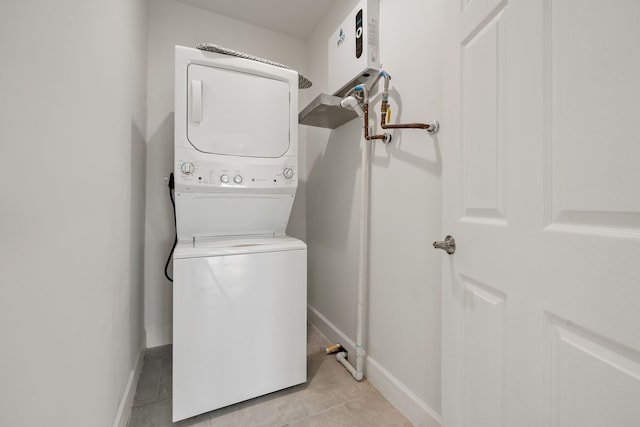 washroom with stacked washer and dryer and light tile patterned floors