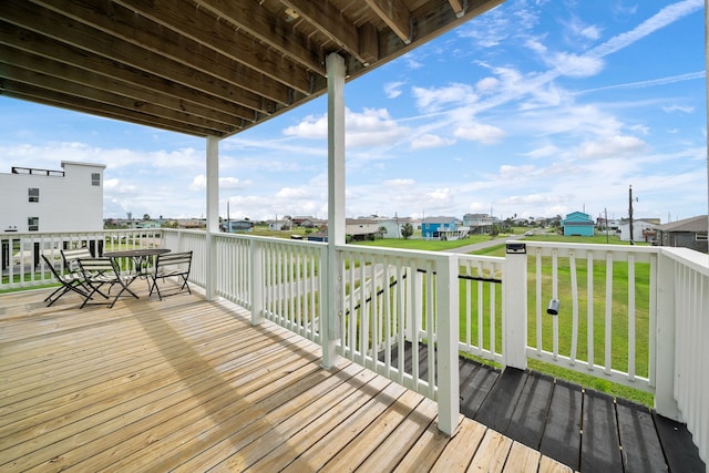 wooden deck with a lawn and a water view