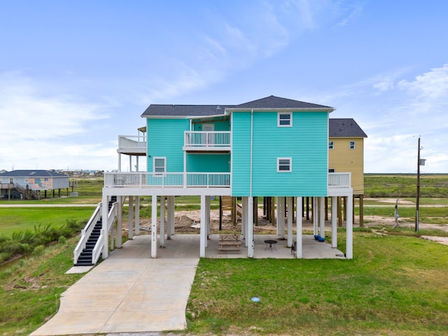 back of property with a yard, a patio area, and a carport