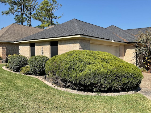 view of side of home featuring a yard and a garage