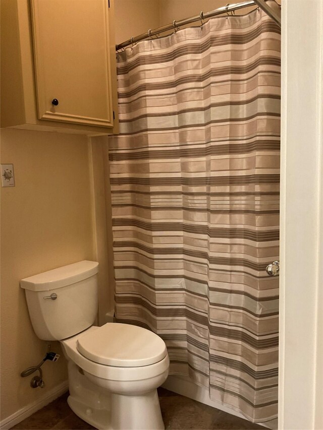 bathroom with tile patterned flooring, a shower with shower curtain, and toilet