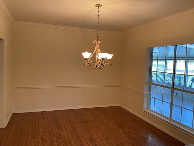 spare room with dark hardwood / wood-style floors, an inviting chandelier, and ornamental molding