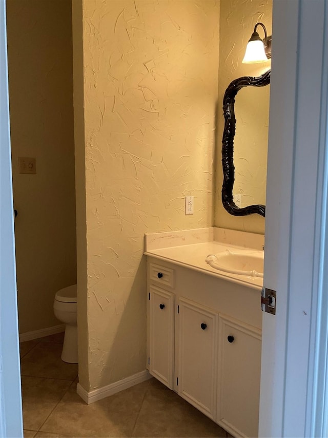 bathroom with tile patterned flooring, vanity, and toilet