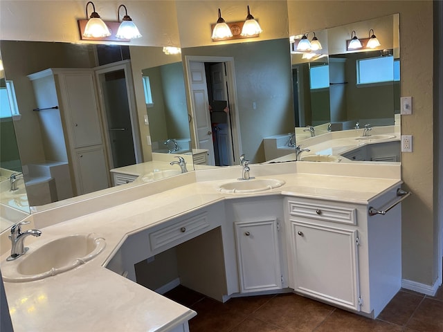 bathroom with a bath, vanity, and tile patterned floors