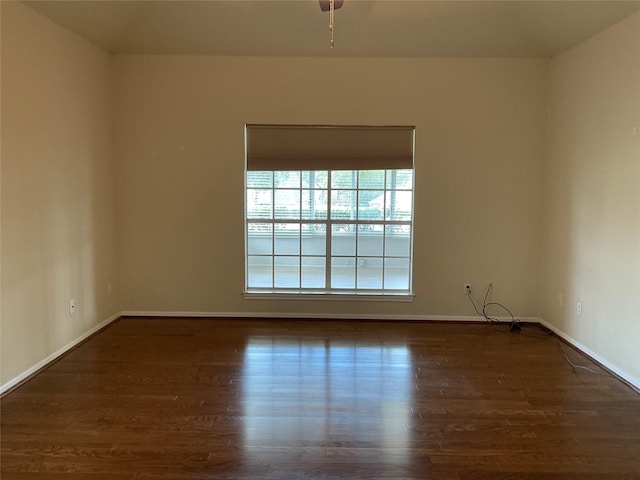 spare room featuring ceiling fan and dark wood-type flooring