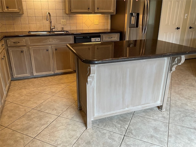 kitchen featuring sink, light tile patterned floors, stainless steel refrigerator with ice dispenser, backsplash, and a kitchen island