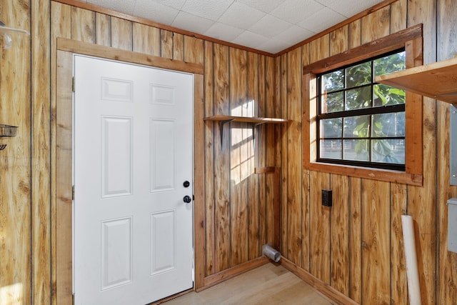 doorway to outside featuring light hardwood / wood-style flooring and wood walls