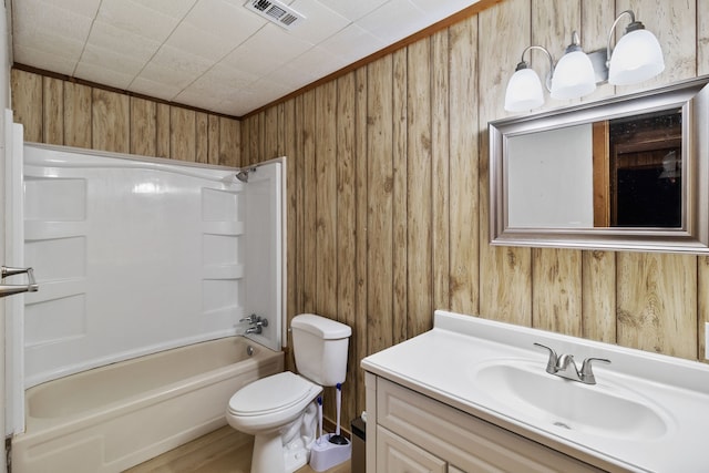 full bathroom with vanity, wood walls, toilet, and bathing tub / shower combination