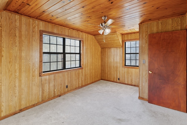 bonus room featuring wooden ceiling, wood walls, ceiling fan, and light colored carpet