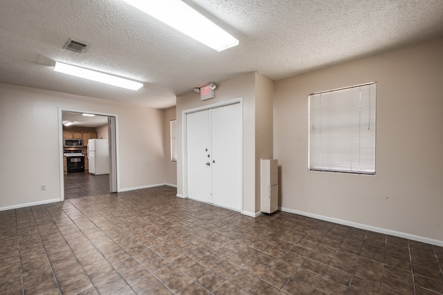 unfurnished room featuring a textured ceiling