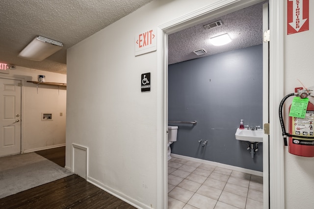 bathroom featuring tile patterned flooring, a textured ceiling, and sink