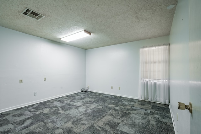 carpeted spare room with a textured ceiling