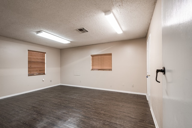 unfurnished room with a textured ceiling and dark hardwood / wood-style floors