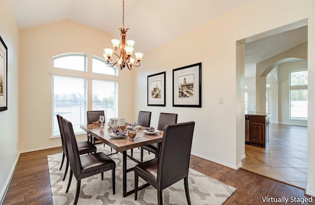 dining space featuring vaulted ceiling, a notable chandelier, and dark hardwood / wood-style flooring