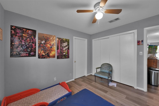 bedroom featuring ceiling fan, wood-type flooring, and a closet