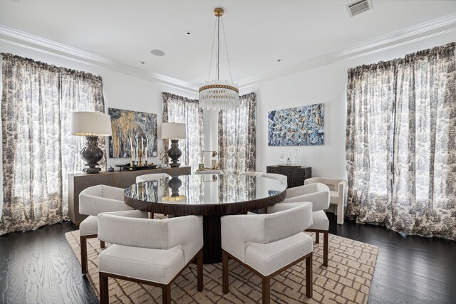 dining space featuring crown molding, dark hardwood / wood-style flooring, and an inviting chandelier