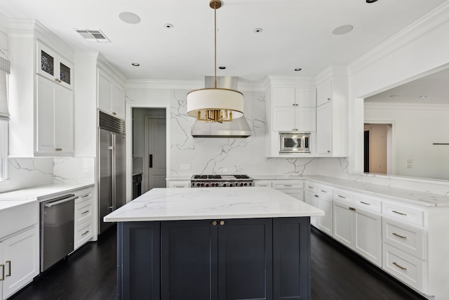 kitchen featuring built in appliances, light stone counters, decorative light fixtures, and white cabinetry