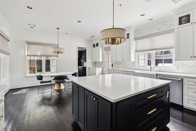 kitchen with pendant lighting, stainless steel dishwasher, a center island, and white cabinets