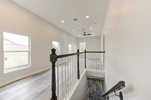 stairs featuring wood-type flooring and ceiling fan