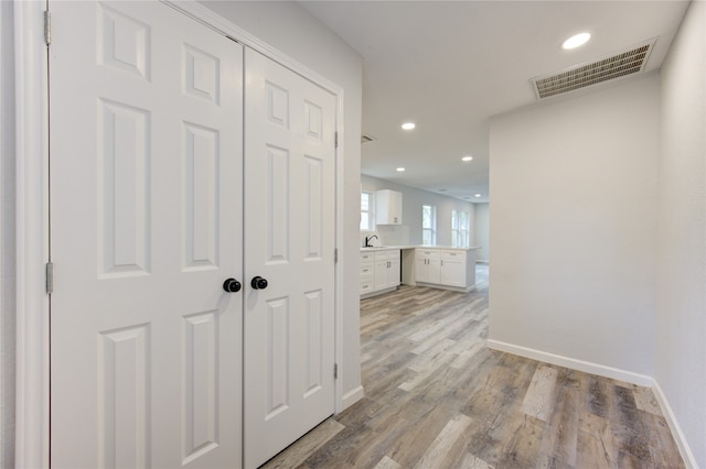 hall with sink and light hardwood / wood-style floors