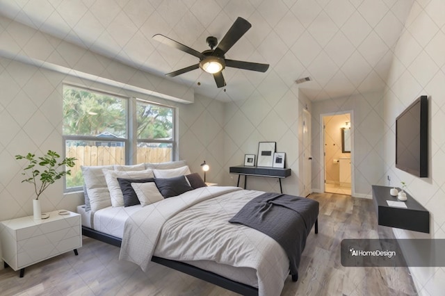 bedroom with ceiling fan, light wood-type flooring, and connected bathroom