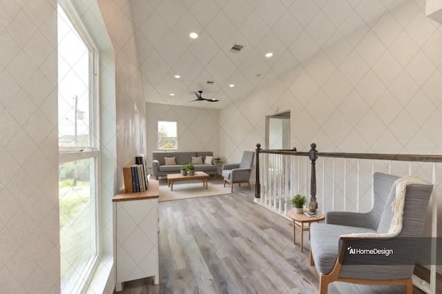 living area featuring a towering ceiling and hardwood / wood-style floors