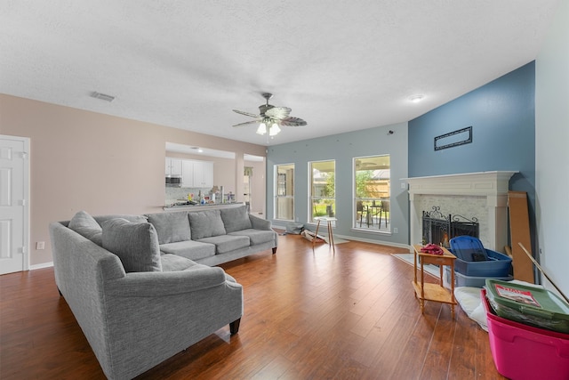 living room featuring a textured ceiling, hardwood / wood-style floors, and ceiling fan