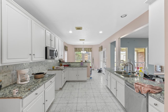 kitchen featuring backsplash, stainless steel appliances, white cabinetry, and sink