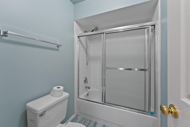 bathroom featuring shower / bath combination with glass door and toilet