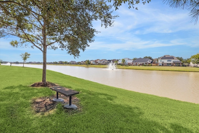 view of community featuring a lawn and a water view