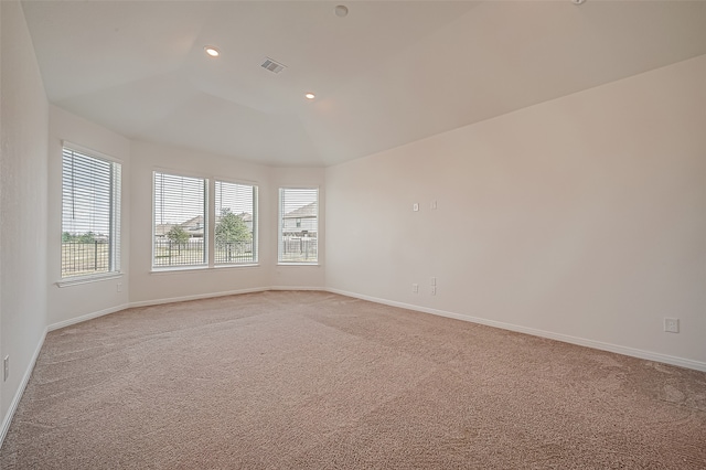 carpeted empty room with lofted ceiling