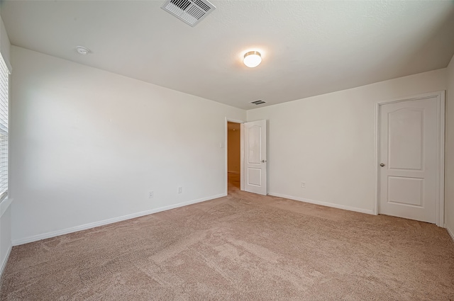 spare room featuring light colored carpet