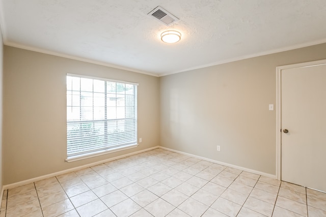 empty room with a textured ceiling, ornamental molding, and light tile patterned floors