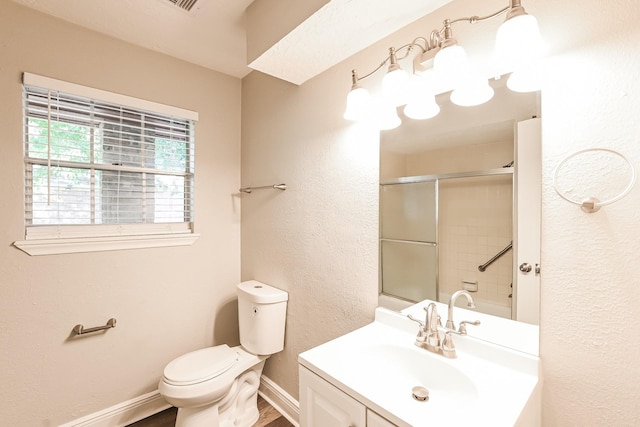 bathroom featuring vanity, baseboards, toilet, a shower with shower door, and wood finished floors
