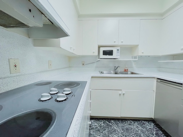 kitchen featuring dishwasher, sink, range hood, white cabinets, and cooktop