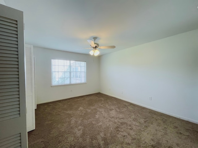 unfurnished bedroom featuring ceiling fan and dark carpet