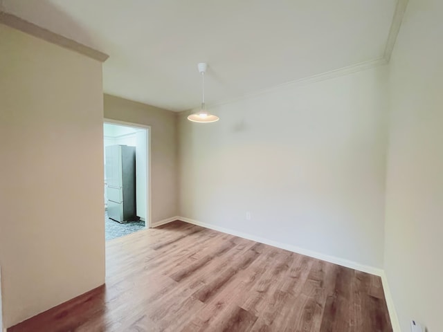 empty room featuring ornamental molding and hardwood / wood-style floors