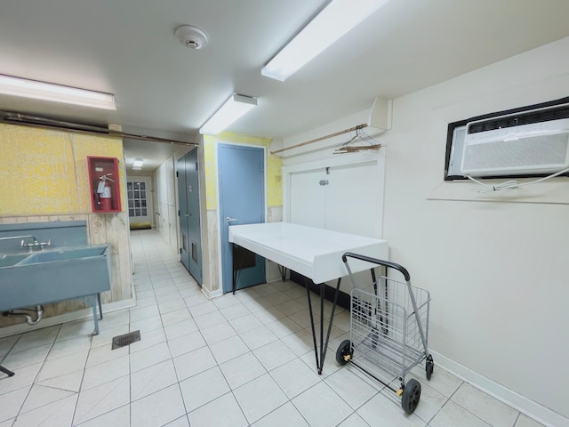 interior space with sink, a wall mounted air conditioner, and tile patterned floors