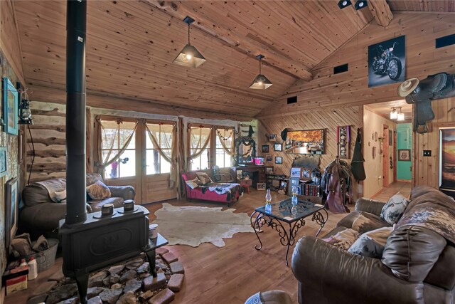 living room featuring beamed ceiling, a wood stove, high vaulted ceiling, hardwood / wood-style flooring, and wooden ceiling