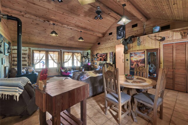 dining room with light tile patterned floors, a wood stove, and wooden ceiling