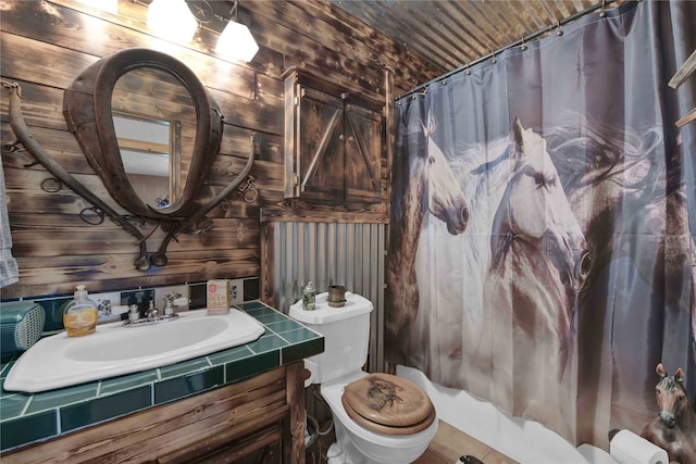 bathroom featuring wooden walls, vanity, and toilet