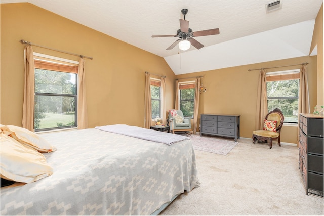 bedroom featuring multiple windows, vaulted ceiling, light carpet, and ceiling fan