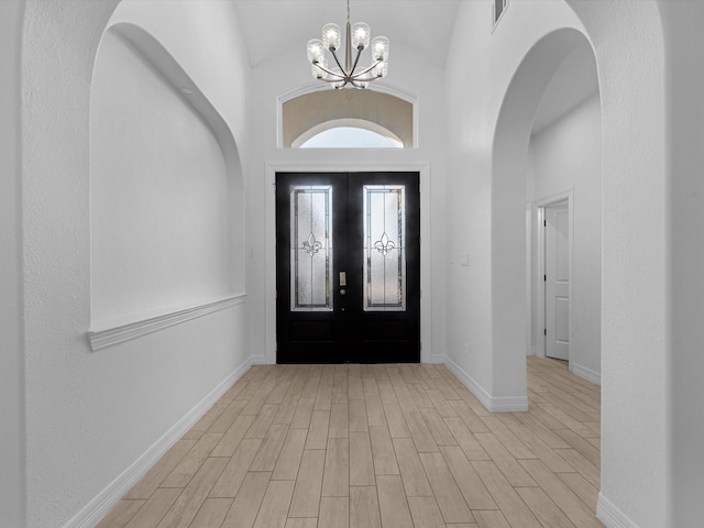 entrance foyer with a chandelier and vaulted ceiling