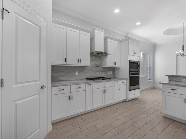 kitchen with appliances with stainless steel finishes, backsplash, wall chimney exhaust hood, crown molding, and white cabinets