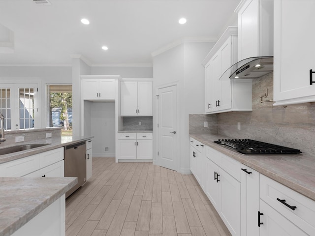 kitchen featuring decorative backsplash, appliances with stainless steel finishes, wall chimney exhaust hood, and sink