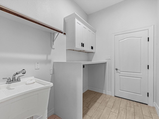 washroom featuring hookup for an electric dryer, cabinets, and sink