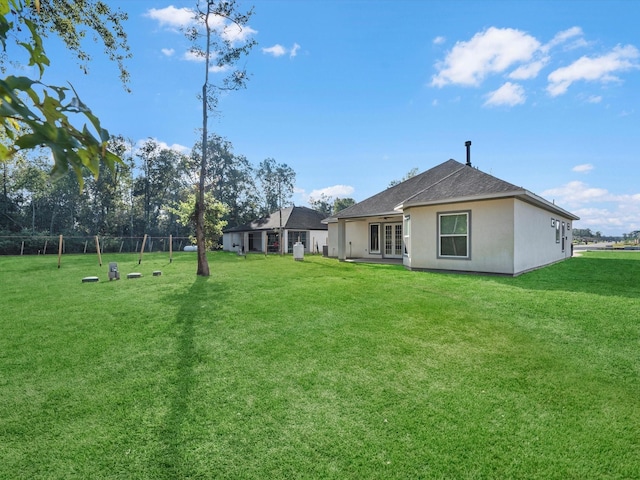 back of property with a yard and french doors