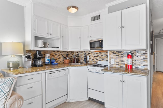 kitchen with white appliances, a sink, visible vents, and white cabinets