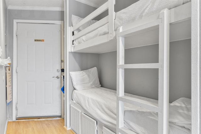 bedroom with light wood-style flooring and crown molding