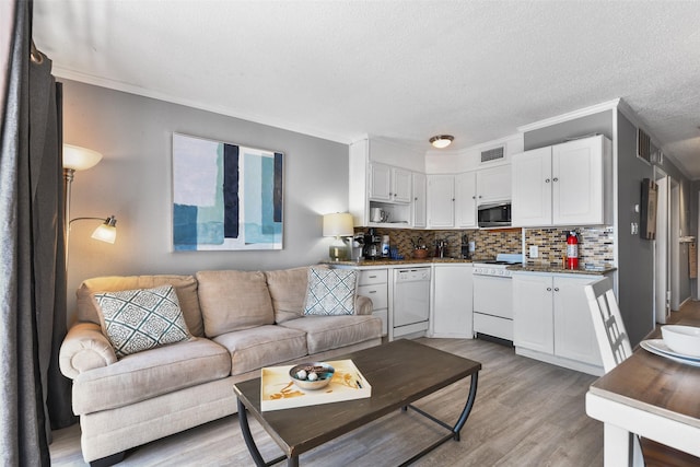 6102 Seawall Blvd Unit 294, Galveston, TX 77551 - living area with light wood finished floors, crown molding, and a textured ceiling